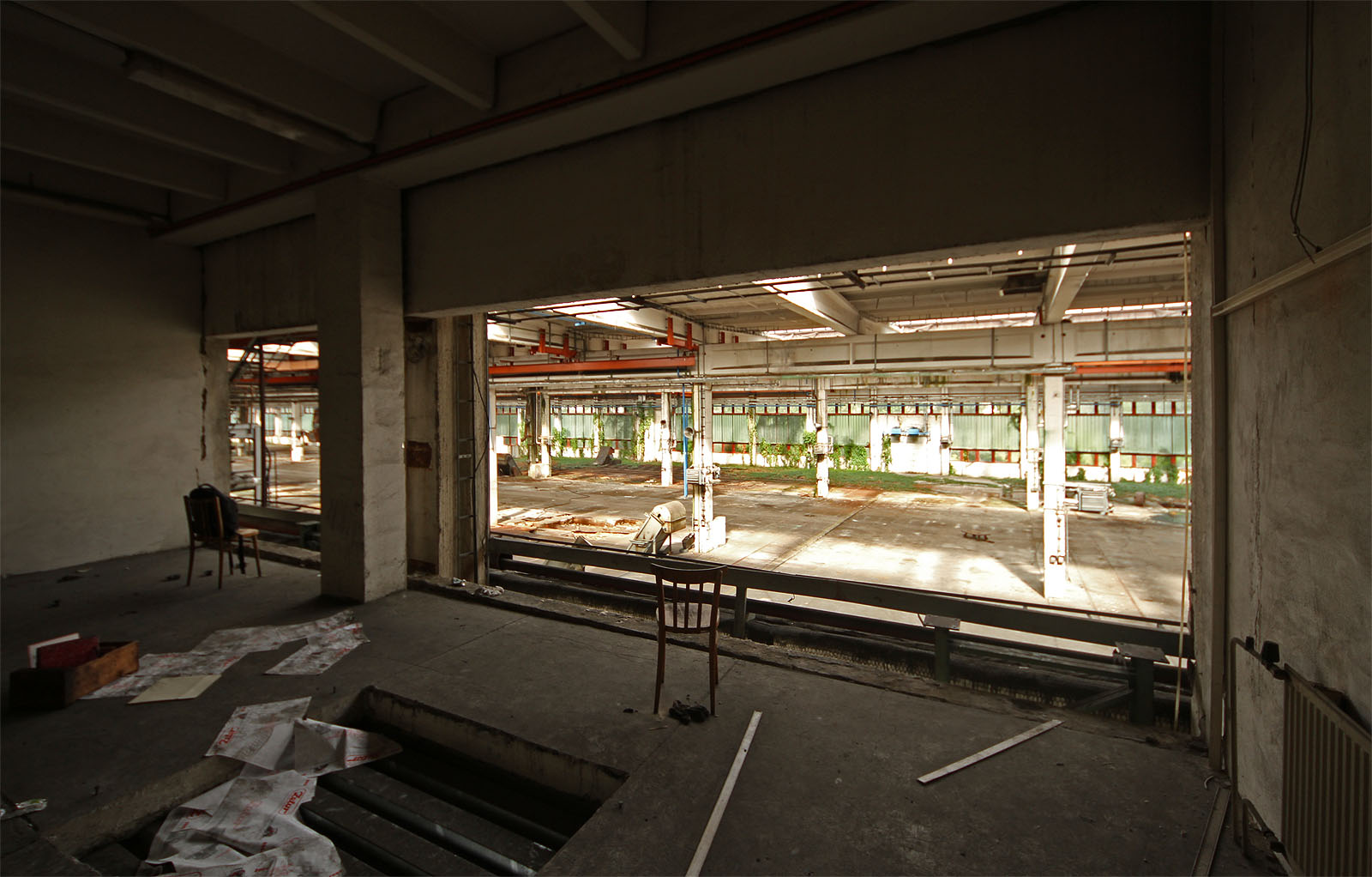Místnost v prvním patře je snad velínem, ze kterého je rozhled na většinu výrobní haly pod oknem.
